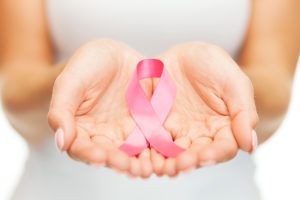hands holding a pink ribbon, breast cancer awareness