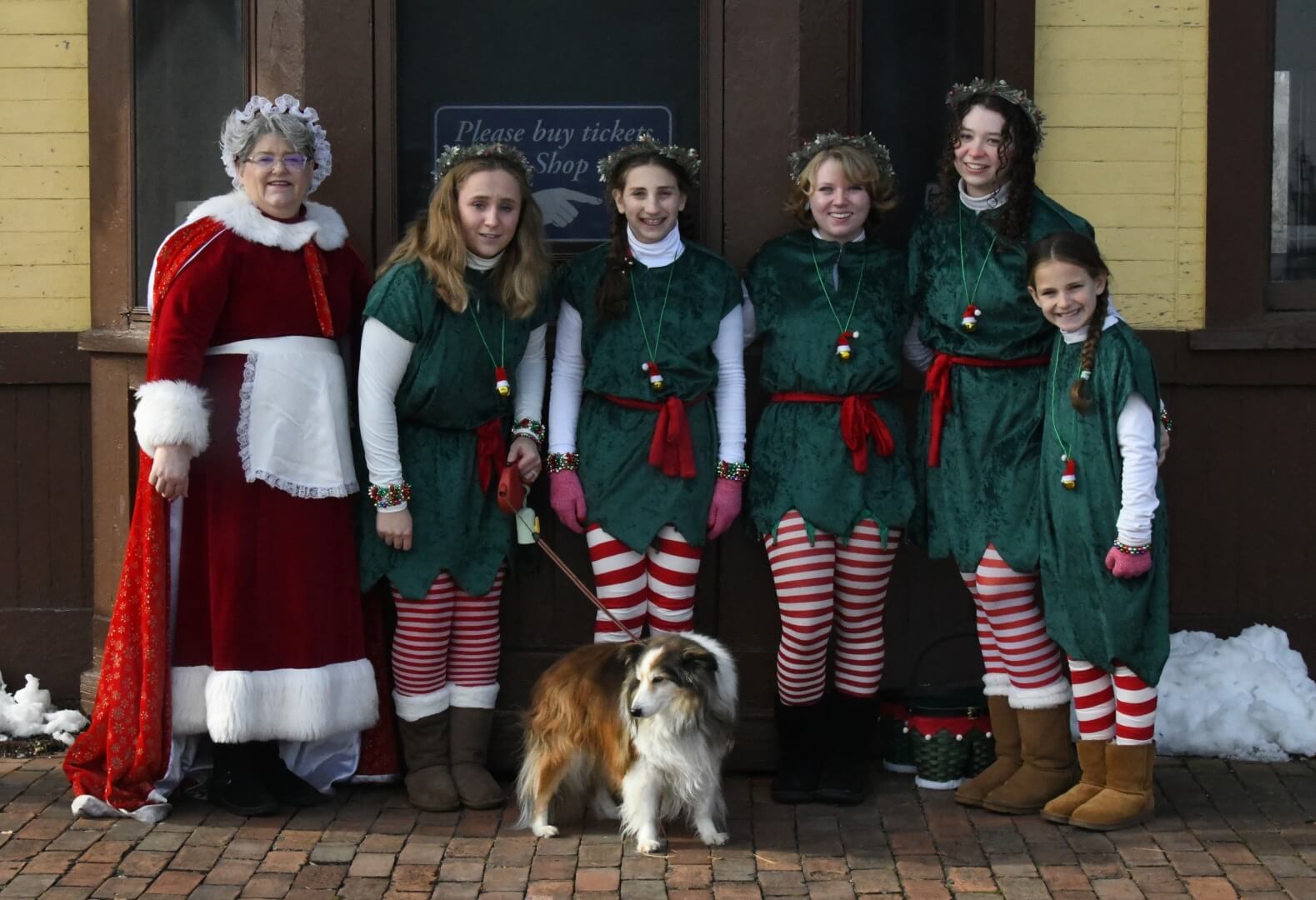mrs claus and elves with their puppy assistant
